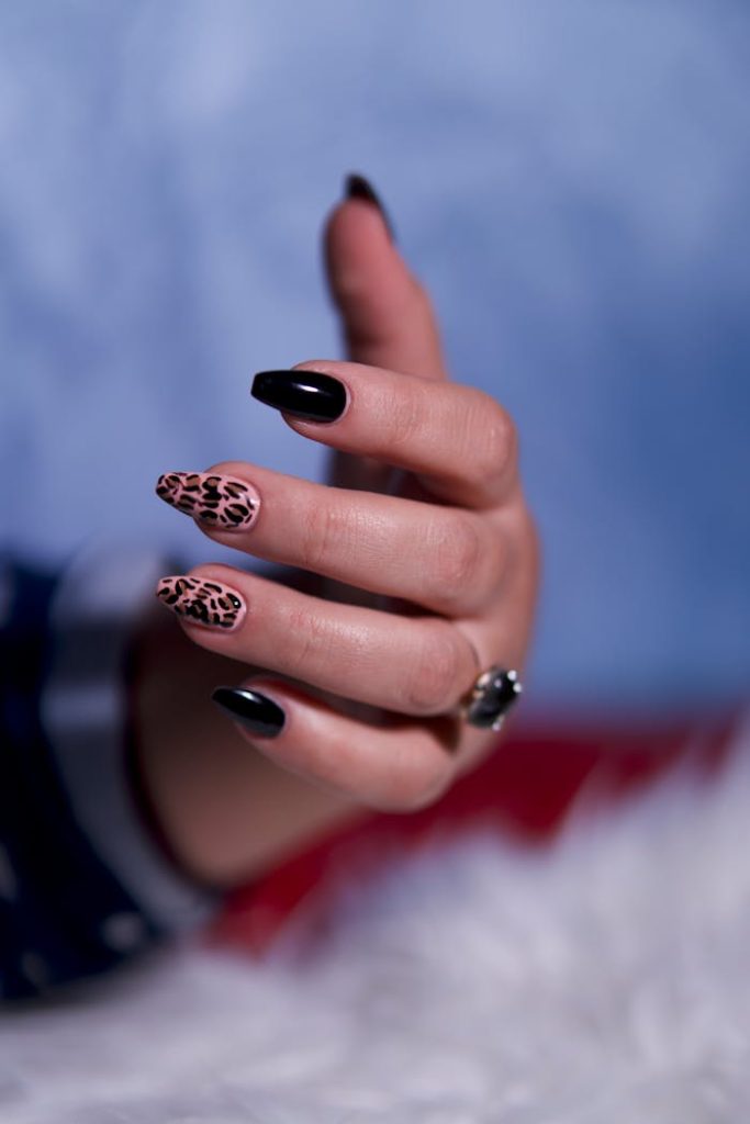 close-up-of-stylish-manicure-with-leopard-print-34835305 Elegant close-up of a hand showcasing black and leopard print nails, perfect for fashion and beauty themes.